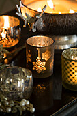 Lit decorative candles with vintage Christmas decorations in Sussex home England UK