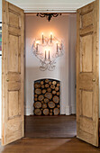 Double doors with view of firewood below lit lights in Surrey home England UK