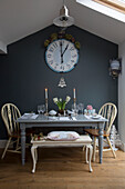 Large clock above grey table with lit candles in London home England UK
