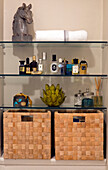 Male toiletries with bust of horses head and baskets on glass shelves in London townhouse apartment UK