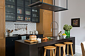 Holzhocker an der Frühstücksbar in einer modernen Küche in einem Londoner Stadthaus UK
