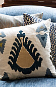 Patterned cushion on blue sofa in London townhouse UK