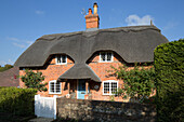 Exterior facade of brick Grade II thatched cottage in Hampshire England UK
