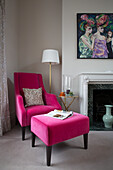 Pink armchair and footstool in Victorian terraced house London England UK