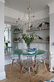 Glas-Esstisch und Sammlung von Holzvögeln mit großem Spiegel in einem Strandhaus in Sussex, England UK