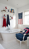 Star shaped cushion on navy blue armchair with freestanding bath in London family home England UK