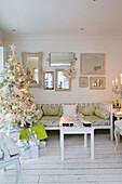 Artificial Christmas tree with collection of mirrors in white living room South London home England UK