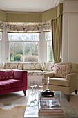 Rosa und cremefarbene Sessel mit Fensterplatz in einem Haus in Gloucestershire, England, UK