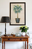 Desk and lamp with framed palm plant in Gloucestershire home England UK
