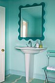 Soap dispenser on modern pedestal base sink with mirror in Gloucestershire farmhouse England UK