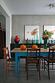 Wooden dining table and chairs with modern art in London home England UK