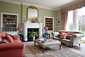 Pair of sofas and ottoman with recessed bookshelves in Grade II listed Georgian country house in Shropshire England UK