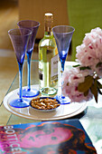 Blue wineglasses and white wine with nuts in London townhouse England UK