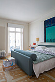 Hues of teal with modern artwork above double bed in London townhouse England UK