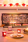 Tealights and mince pies in kitchen with splashback of family photos in Hampshire England UK