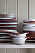 Stacked ceramic plates in kitchen detail of Midlothian cottage Scotland UK
