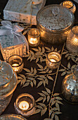 Lit tealights with silver leaves and gifts wrapped with ribbon in Kent England UK