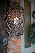Angezündete Kerze in einem hölzernen Kerzenhalter an der Haustür in Cheshire, England