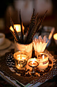 Federn und brennende Kerzen mit Ölbrenner und Nelken in einem Haus in Cheshire, UK