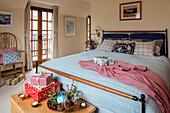 Pinker Bademantel auf Doppelbett mit Weihnachtsgeschenken in Haus in Berkshire UK