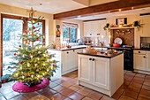 Lit Christmas tree in white fitted kitchen of Berkshire home UK