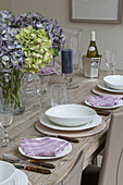 Place setting with hydrangea on dining table in London townhouse UK