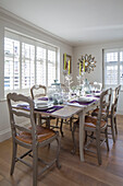 Painted chairs at dining table in West Sussex home