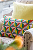 Geometric cushion on armchair in Oast house conversion Kent UK