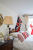 Union Jack over antique double bed in London townhouse UK
