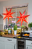 Zwei beleuchtete Sterne im Küchenfenster eines Londoner Stadthauses UK