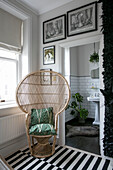 Wicker chair with black and white striped rug in doorway of Hove apartment East Sussex UK