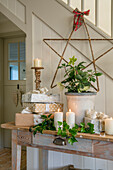 Bamboo star and side table with lit candles and presents in West Sussex farmhouse UK