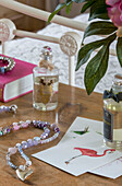 Perlenhalskette und Parfümflaschen auf Holztruhe in Alford Schlafzimmer Surrey UK