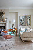 Perspex chairs and two seater sofa with gilt framed artwork in entrance hall of West Sussex townhouse UK
