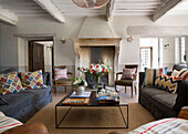 Patterned cushions on sofas with low coffee table in 19th century Provencal farmhouse France