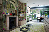 Car track and shelves with tropical wallpaper in open plan Victorian London townhouse UK