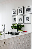 Framed black and white prints with houseplant and gas hob in Grade II listed villa Arundel West Sussex UK