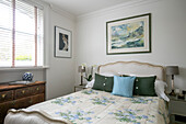 Seascape above double bed with floral quilt at window in Grade II listed villa Arundel West Sussex UK