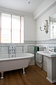 White pedestal basin with freestanding bath at window in Grade II listed villa Arundel West Sussex UK