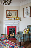 Tartan-Sessel am Kamin mit gemustertem Teppich in einem Reihenhaus im Arts-and-Crafts-Stil Sevenoaks Kent UK