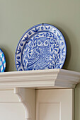 Blue and white ceramic plate with decorative owl on shelf in Arts and Crafts kitchen Sevenoaks Kent UK