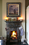 Framed artwork above metallic art deco fireplace in Hampshire home