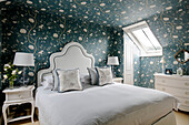 Floral wallpaper and skylight window in bedroom of Wiltshire home England UK