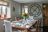 Large clock in light grey dining room of Somerset farmhouse UK