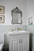 Decorative silver mirror above washbasin in Victorian terraced home London UK