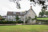 Lawn and driveway of detached stone three-storey house Somerset, UK