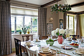 Mismatched chairs at square wooden dining table in Somerset home UK
