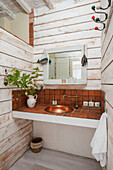 Waschbecken aus Kupfer mit Messing in einem weiß getünchten Badezimmer eines mittelalterlichen Hauses aus dem 13