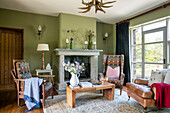 Sessel und Couchtisch im grünen Wohnzimmer eines Hauses in Devon UK