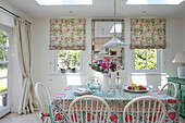 Dining table and chairs with mirror below skylight in Hampshire home UK